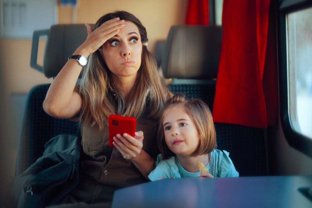 A frustrated woman holding a phone on a train, representing unstable Shinkansen Wi-Fi