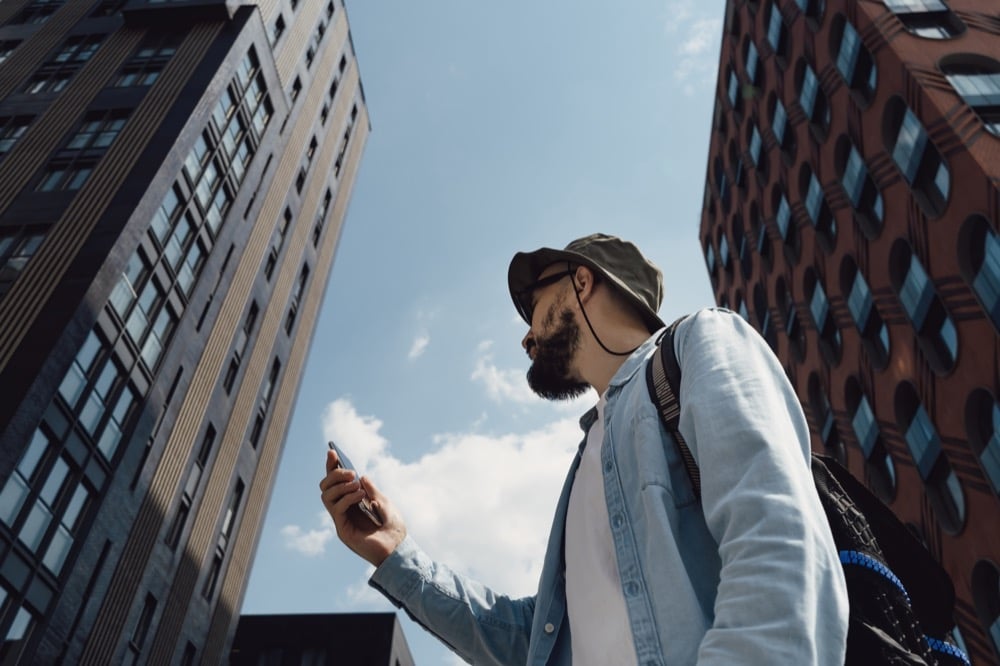 A traveler gazing up at city skyscrapers