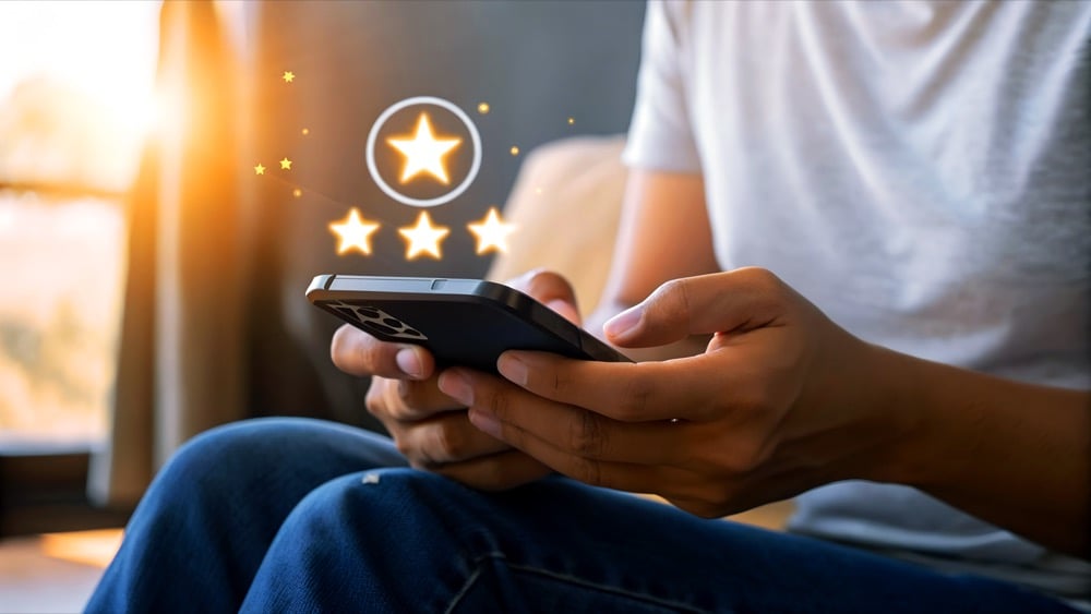 Hands holding a smartphone with floating star rating icons representing user reviews of Japan travel options
