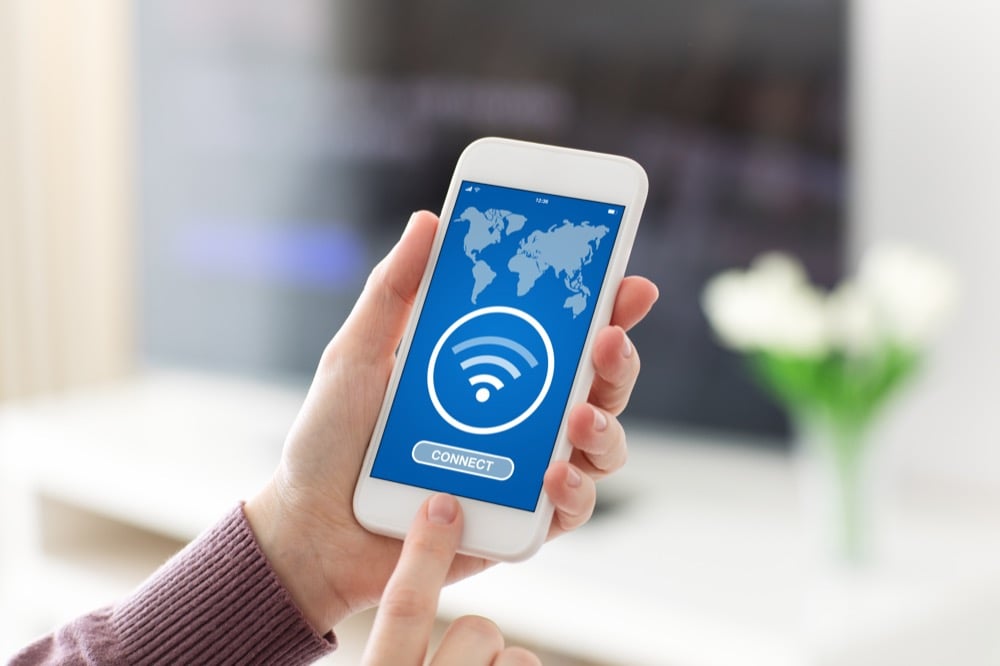 Hand holding a phone displaying a Wi-Fi connection screen