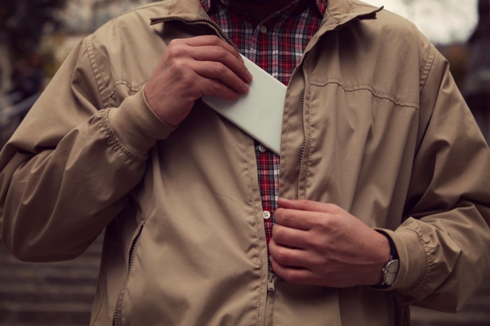 A man putting a pocket Wi-Fi into his chest pocket
