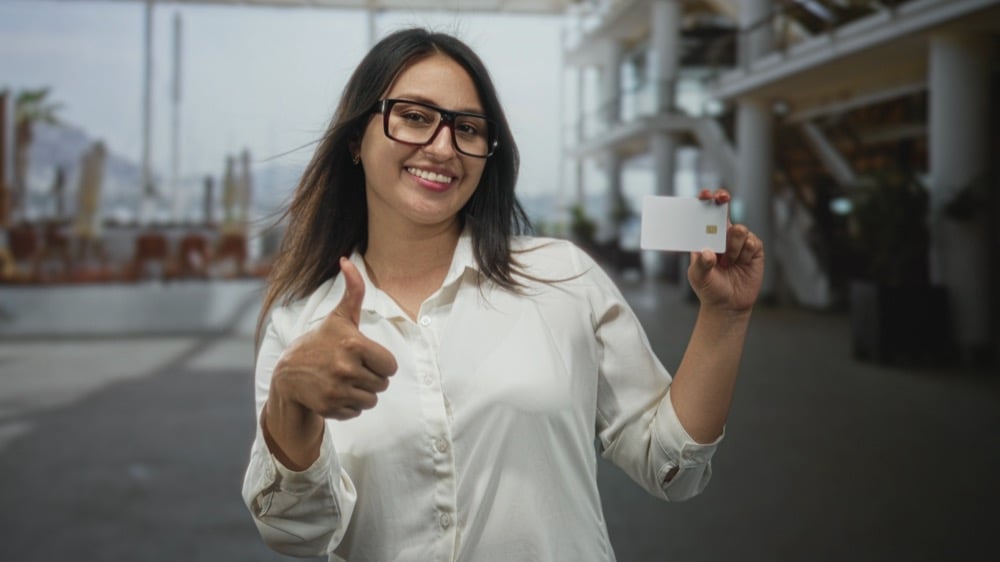 A woman showing her IC card with a thumbs-up sign