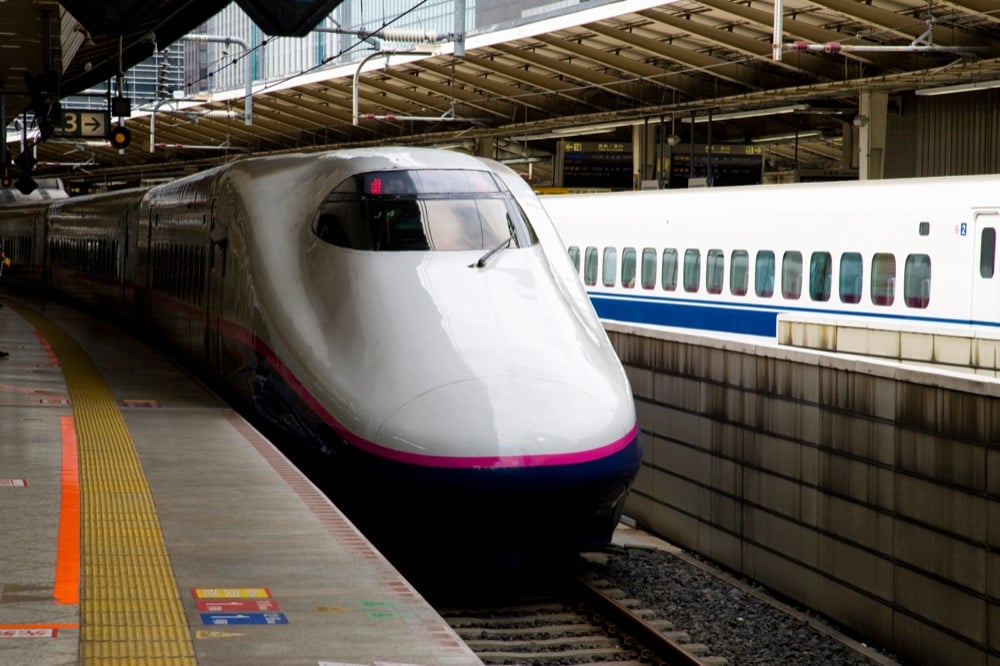 A Shinkansen bullet train at a station platform, ready for departure