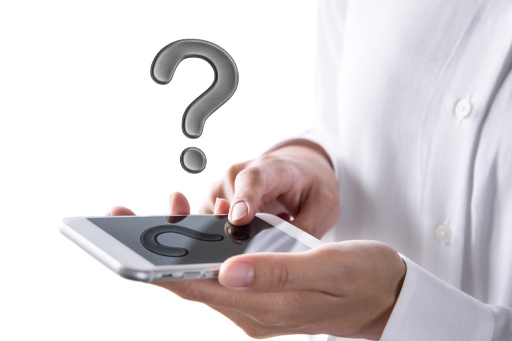 Hands holding a tablet with a floating question mark representing ANA Wi-Fi frequently asked questions