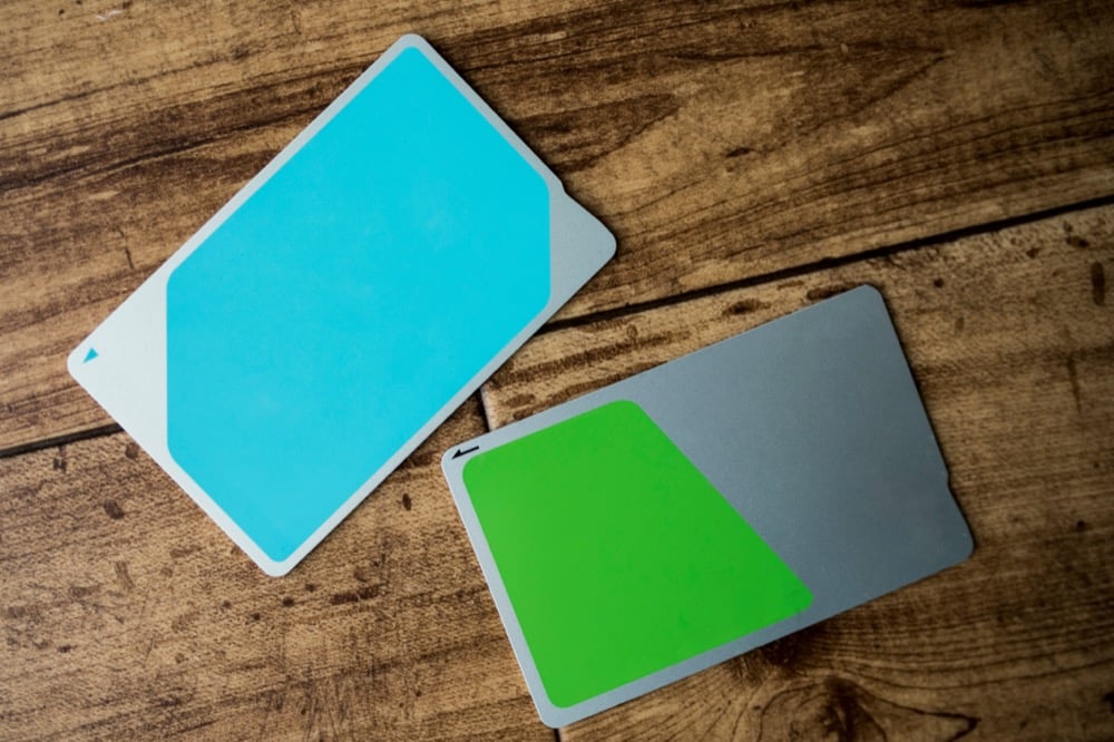 Two IC transit cards on a wooden surface representing Suica and PASMO card options for Japan travel