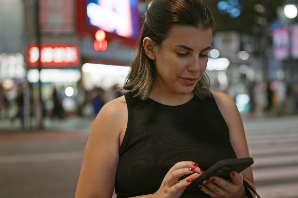 A woman using a phone on the streets of Tokyo