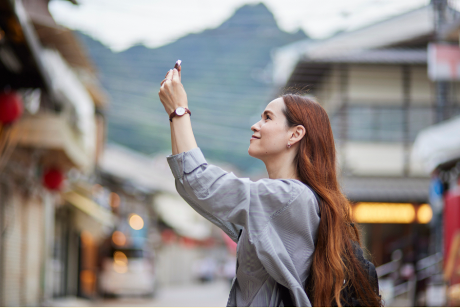 A foreign woman using a smartphone while sightseeing in Japan