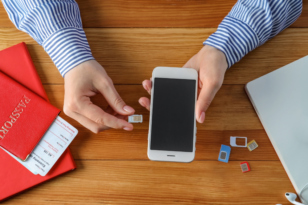 A person inserting a SIM card into an iPhone