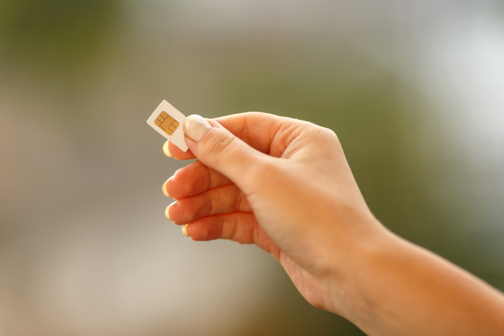 A person with a SIM card in their hand