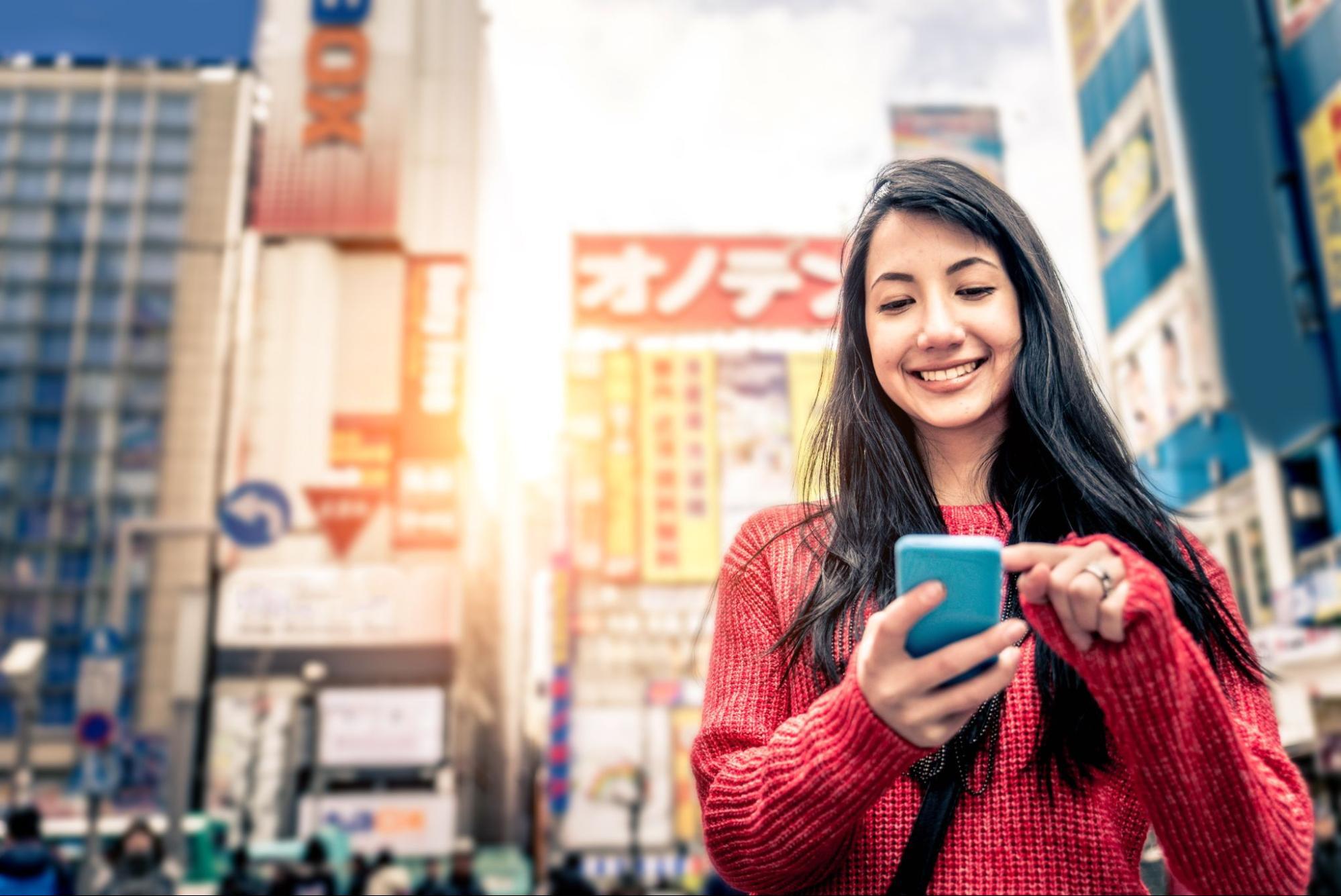 A foreign female tourist using her smartphone