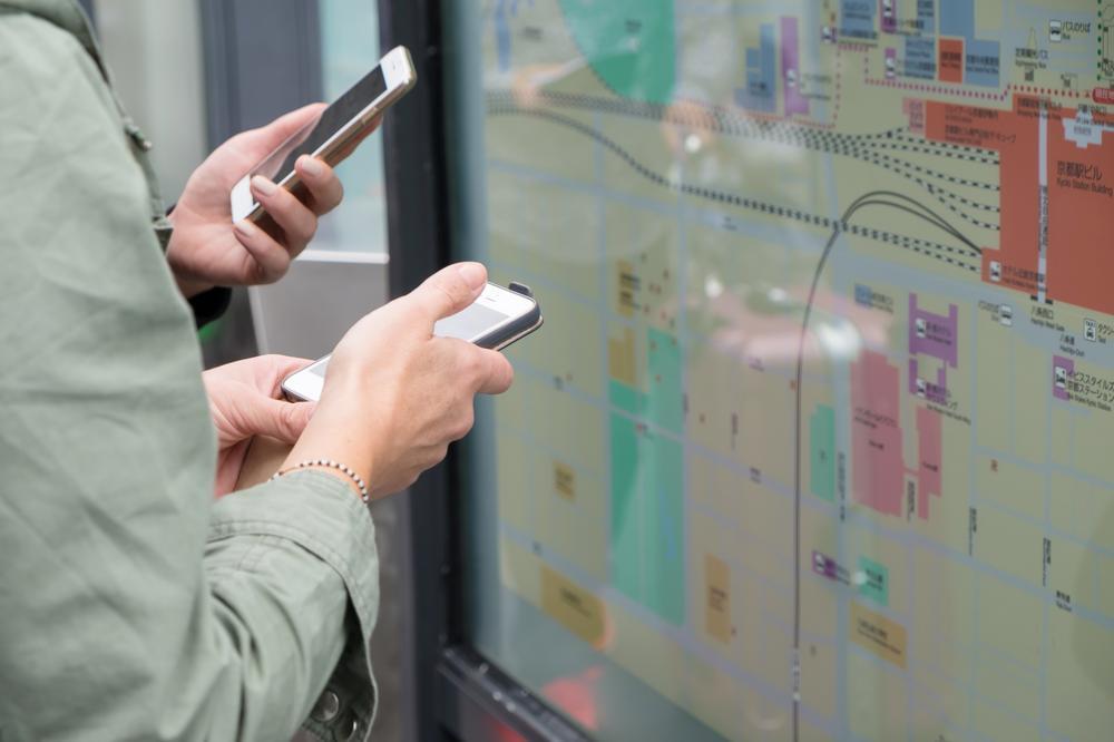 Two people stand close together, holding smartphones in their hands