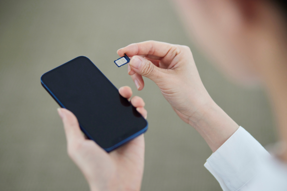 A woman taking out a SIM card from her phone