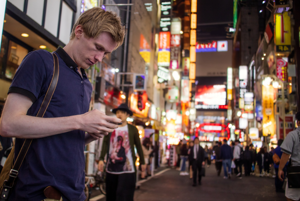 A man tourist in Japan using her smartphone with an eSIM