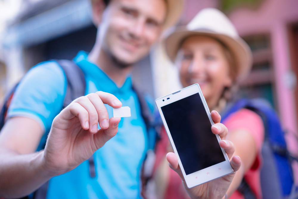 A young couple using eSIMs on their smartphones