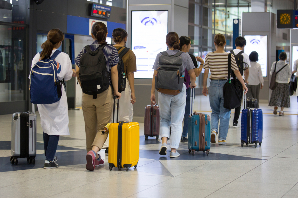 Foreign visitors to Japan walking with their luggage after arriving at the airport