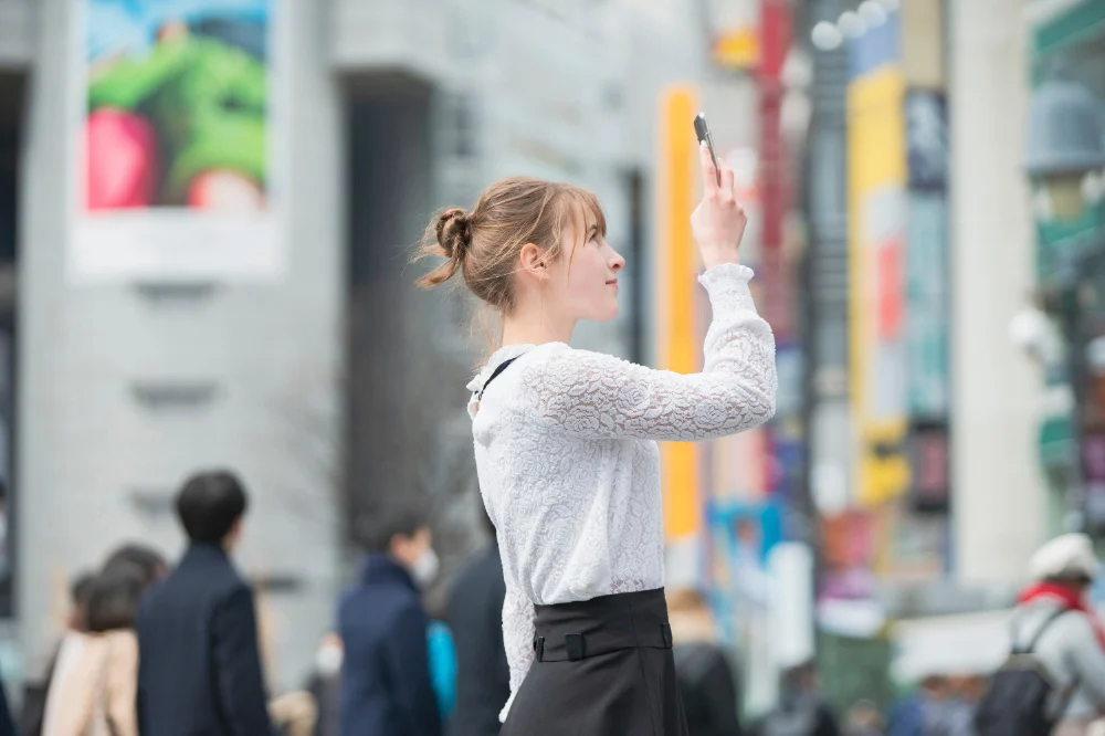 A woman using a smartphone with WiFi in Japan