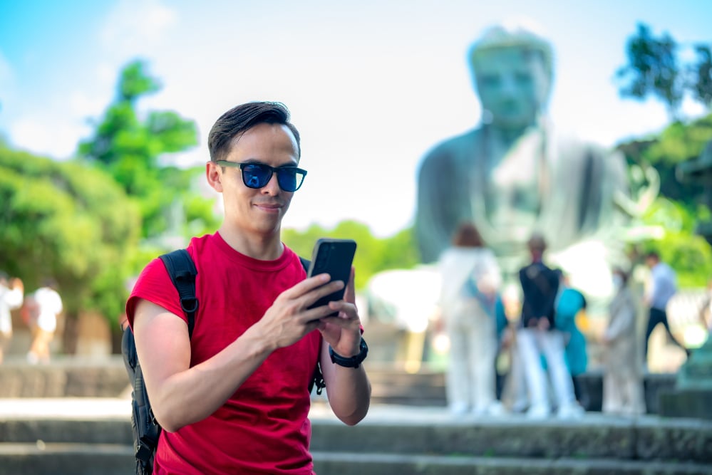 A foreign man using a smartphone while connected to WiFi in Japan