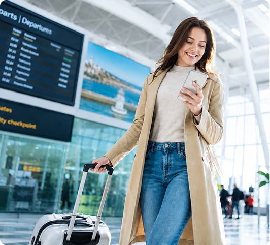 A traveler walking with a smartphone in front of world city landmarks